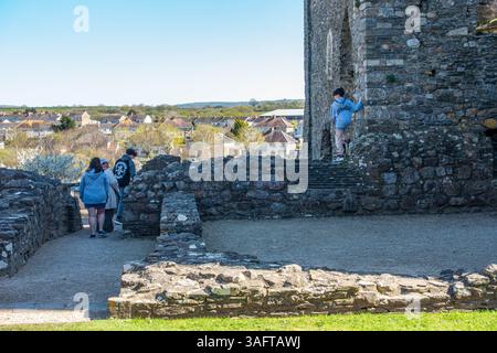 I visitatori esplorano le rovine del castello di Kidwelly nel Camarthanshire, Galles, Regno Unito Foto Stock