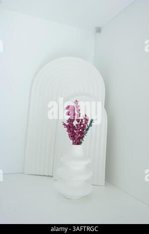Decorazioni moderne con fiori rosa in un ambiente minimalista Foto Stock