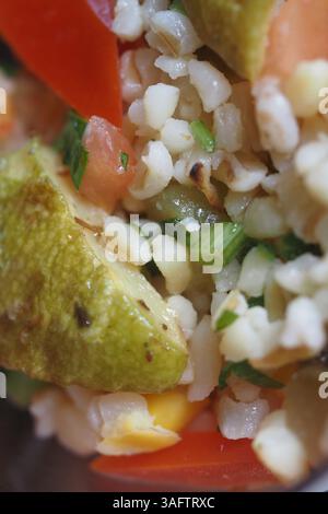 Insalata colorata di cereali con verdure fresche ed erbe aromatiche nel recipiente Foto Stock