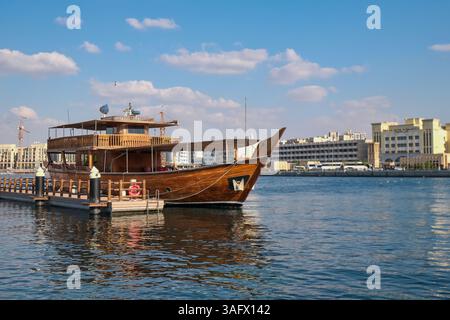 Vecchia nave in legno d'epoca ormeggiata nel porto di Deira creek per una crociera turistica in dhow. Ristorante galleggiante nel porto di Dubai Foto Stock