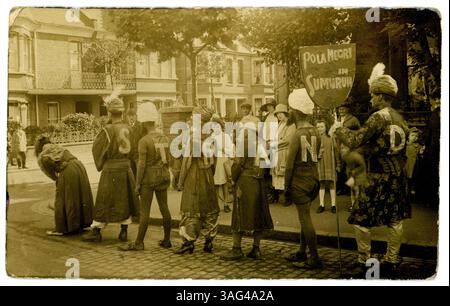 Il gruppo originale degli anni '1920 sfilava nella periferia di Londra con striscioni che promuovevano un primo film muto con l'attrice polacca - Pola Negri in un primo film muto intitolato "Sumarun" uscito nel 1920. Forse questa è una processione di carnevale. Gli uomini pubblicizzano questo film muto del 1920 che appare con le lettere per "Strand" ricamate sui loro costumi che sono di un tema arabo, sono oscurati indossando turbanti e lunghe tuniche. Il cinema all'epoca in The Strand si riferisce probabilmente al cinema di Terry che ha aperto nel 1910 e ha mostrato film fino al 1923, quando è stato demolito. The Strand, Londra, Regno Unito 1920 -1922. Foto Stock