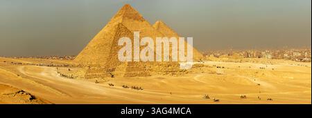 Mostra le iconiche piramidi di Giza con questa vista panoramica, una testimonianza delle antiche meraviglie dell'Egitto. Perfetto per la storia. Foto Stock