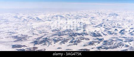 Vista mozzafiato ad alta quota delle montagne innevate di Tangula sull'altopiano tibetano in Cina, vista dalla finestra di un aeroplano durante Foto Stock