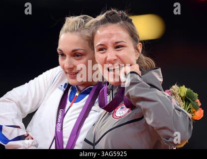 30 luglio 2012 - Londra, GBR - Marti Malloy degli Stati Uniti ha morso la sua medaglia di bronzo nel judo femminile di 57 kg, lunedì 30 luglio 2012 durante i 2012 Giochi Olimpici estivi di Londra, Inghilterra, lunedì 30 luglio 2012. Accanto a lei si trova Automne Pavia della Francia, che ha ricevuto anche una medaglia di bronzo. (Immagine di credito: © Karl Mondon/Contra Costa Times/MCT/ZUMAPRESS.com) Foto Stock
