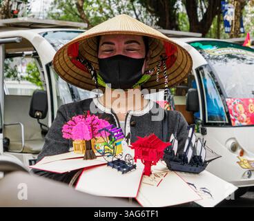 Donna che vende cartoline ai turisti di Hanoi, Vietnam Foto Stock