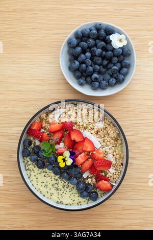 Sana prima colazione con frullato di avocado con frutta fresca e semi di chia su un tavolo di legno Foto Stock