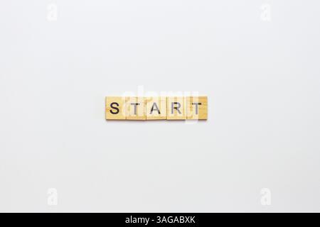Blocchi di legno che scrivono la parola "START" su uno sfondo bianco, a indicare un nuovo inizio o un lancio di un progetto. Foto Stock