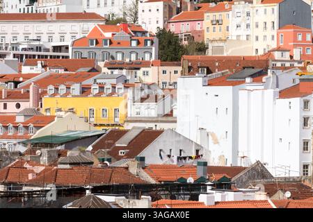 Vista panoramica dei tetti e degli edifici colorati di Lisbona, Portogallo, che mostrano la tradizionale architettura mediterranea in una luce calda e vivace Foto Stock