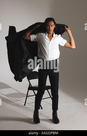 Uomo sicuro con elegante giacca regolabile in un moderno studio di moda. stile, sicurezza, sartoria, abbigliamento da uomo, eleganza, alla moda Foto Stock