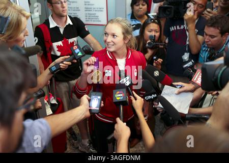 13 agosto 2012 - Mississauga, Ontario, Canada - la trampolinista ROSANNAGH ''ROSIE'' MACLENNAN mostra il suo hardware d'oro ai media e ai tifosi mentre lei e molti altri atleti canadesi sono atterrati sul suolo di casa questo pomeriggio. L'unica atleta canadese a vincere l'oro per la sua routine con il trampolino, battendo diversi atleti cinesi favoriti alle recenti Olimpiadi di Londra del 2012. Il Canada finì i Giochi di Londra con 18 medaglie Ã un oro, cinque argento e 12 bronzo. (Immagine di credito: © Christopher Drost/SHIFT digital/ZUMAPRESS.com) Foto Stock