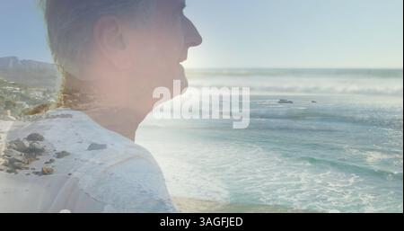Immagine di una luce incandescente su un ritratto di un uomo anziano felice al mare Foto Stock