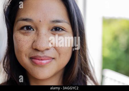Donna sorridente che gode di una giornata di sole all'aperto, ritratti ravvicinati con luce naturale. felicità, allegria, luce del sole, donna, stile di vita Foto Stock