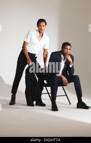 Uomini sicuri di sé con abiti eleganti in posa in un moderno ambiente da studio di moda. abbigliamento da uomo, eleganza, stile, sicurezza, abbigliamento formale, tendenza Foto Stock