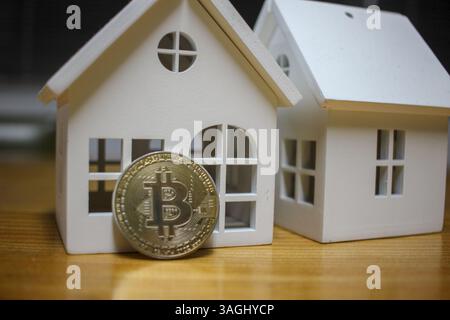 bitcoin di fronte a una casa. bitcoin o stato reale come investimento Foto Stock