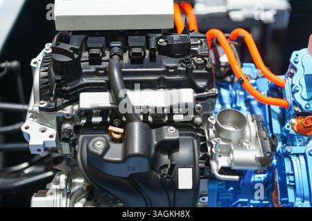 vista dettagliata di una catena cinematica ibrida che mostra sia il motore a combustione interna che il cablaggio ad alta tensione per prestazioni ecocompatibili. Foto Stock