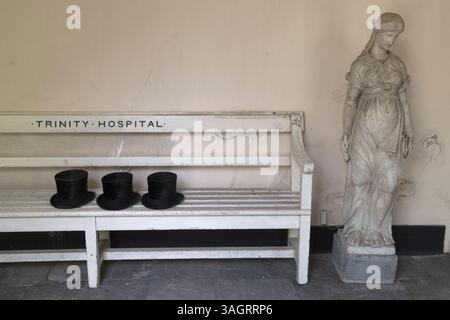 Cappelli in alto lasciati sulla panchina fuori dalla cappella del Trinity Hospital Almshouse, Greenwich. Gli uomini residenti prendono parte all'annuale servizio di ringraziamento della Visitation Court Day nella cappella di Almshouse. L'Almshouse è l'edificio più antico di Greenwich. Sud-est di Londra, Inghilterra anni '2019 2010 Regno Unito HOMER SYKES Foto Stock