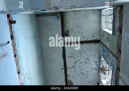 Una vecchia casa in rovina con scale crollate e lastre di pavimento. Foto Stock