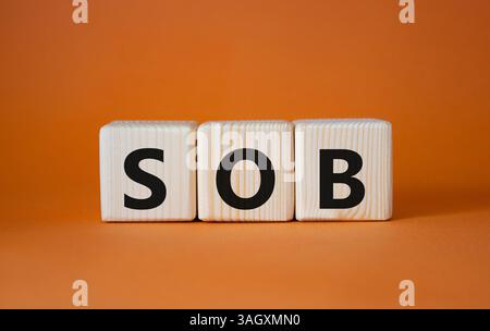 SOB - simbolo respiro corto. Cubi di legno con parole SOB. Bellissimo sfondo arancione. Concetto medico e SOB. Copia spazio. Foto Stock