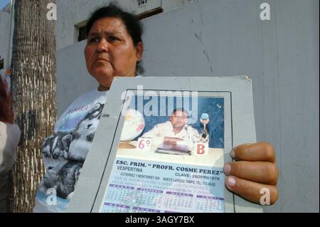 27 giugno 2005 - Nuevo Laredo, Tamaulipas, Messico - PAULA SANCHEZ, 46 anni, ha tenuto la foto del figlio sedicenne scomparso, NICOLAS ROJAS. Sanchez era tra le decine di persone che aspettavano fuori da una guarnigione militare a Nuevo Laredo, in Messico, nella speranza che suo figlio fosse tra le 43 vittime rapite salvate dai soldati messicani. (Immagine di credito: © Luis J. Jimenez/ZUMA Press) Foto Stock