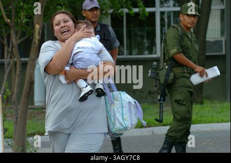 27 giugno 2005 - Nuevo Laredo, Tamaulipas, Messico - eccitato dalla notizia che suo marito, JUAN VALENTIN OCANAS, era stato salvato dai soldati a Nuevo Laredo, Messico, la moglie della vittima del rapimento ha abbracciato la figlia. Ocanas era una delle 43 vittime liberate da case sicure in un'operazione militare. La donna si rifiutò di dare il suo nome, dicendo che aveva paura di rappresaglie. (Immagine di credito: © Luis J. Jimenez/ZUMA Press) Foto Stock