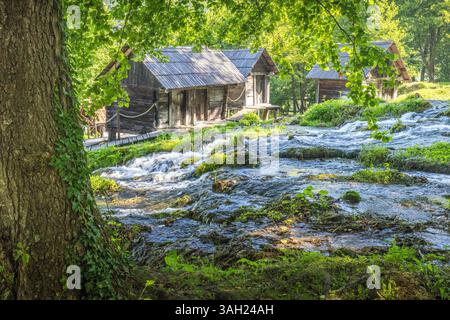 I mulini ad acqua in legno di Mlincici sul fiume Pliva vicino alla città di Jajce in Bosnia ed Erzegovina, Europa. Pittoresche cabine di legno si trovano lungo un ruscello con Foto Stock