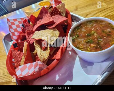 Patatine tortilla colorate con salsa in una cena informale vista a livello dell'occhio Foto Stock