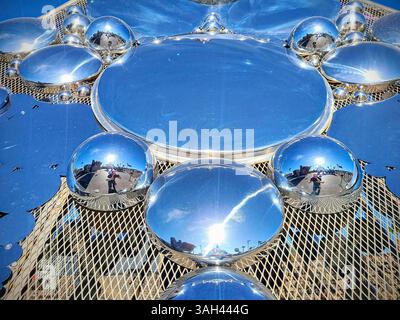 Sfere metalliche riflettenti sulla superficie mesh alla luce del sole urbano a livello degli occhi Foto Stock