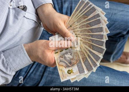 Soldi della Polonia. Uomo che tiene in mano un fan di 200 banconote zloty. Concetto di business finanziario Foto Stock