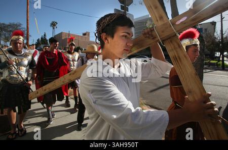 3 aprile 2015 - San Diego, CA, USA - 3 aprile 2015 San Diego, CA. USA | Francesco Russo, 16 anni, come Gesù, porta la sua croce, circondata da soldati romani, attraverso il centro di San Diego venerdì mattina..la 24a edizione annuale delle stazioni della Croce del venerdì Santo con la sofferenza si spostò attraverso il centro di San Diego venerdì mattina, a partire dalla missione di soccorso, fermandosi in varie chiese, edifici federali, la prigione e le organizzazioni caritative sulla via del ritorno alla missione per la stazione finale. La processione fu eseguita da studenti della St. Augustine High School, e organizzata dall'Interfaith CH Foto Stock