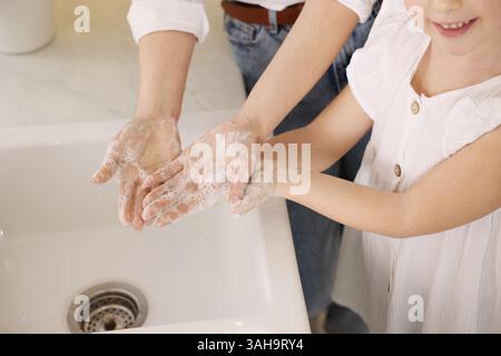 Madre e figlia si lavano le mani al chiuso, primo piano Foto Stock