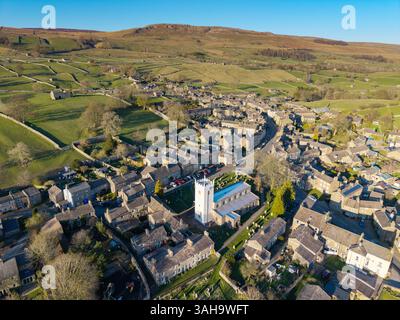 La chiesa parrocchiale di St Oswalds ad Askrigg, Wensleydale, in una piacevole serata primaverile, con il suo controverso campanile bianco recentemente rinnovato, che Foto Stock