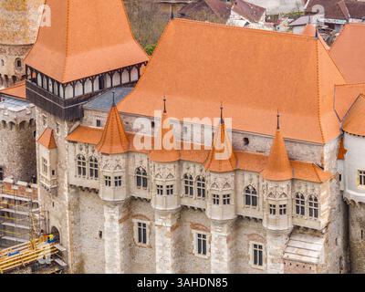 Vista aerea ravvicinata del castello di Corvin a Hunedoara in Romania, palazzo gotico restaurato con tetto rosso Foto Stock
