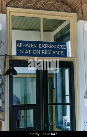 7 aprile 2025 - Wognum-Paesi Bassi: Ingresso della stazione ferroviaria vintage con dettagli in legno e cartello olandese originale "Afhalen Expresgoed" sopra la d Foto Stock