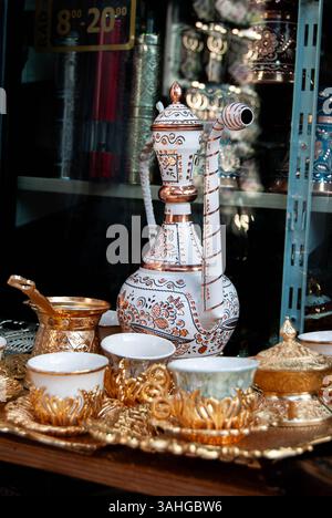 Set da tè in rame dai toni caldi che trasuda fascino antico in un ambiente elegante. Foto Stock