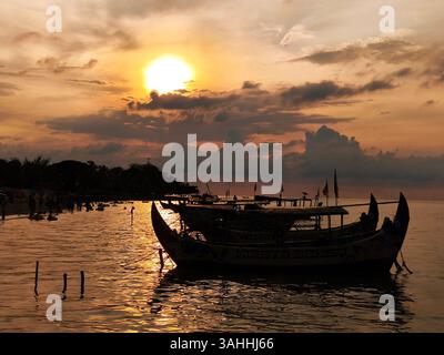 Silhouette di una barca di legno sulla spiaggia di Bandengan, Jepara, Giava centrale, Indonesia al crepuscolo Foto Stock