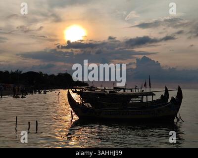 Silhouette di una barca di legno sulla spiaggia di Bandengan, Jepara, Giava centrale, Indonesia al crepuscolo Foto Stock