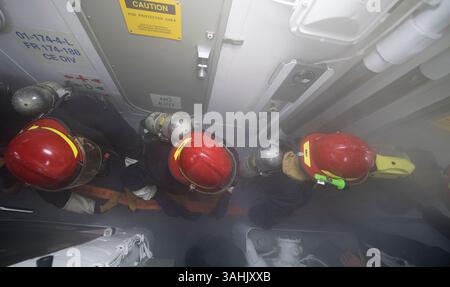 10 aprile 2017 - Mar Cinese meridionale - i marinai combattono un fuoco simulato durante un'esercitazione di controllo dei danni a bordo del cacciatorpediniere missilistico guidato classe Arleigh Burke USS Michael Murphy (DDG 112). Michael Murphy è impegnato in un dispiegamento programmato nel Pacifico occidentale con il Carl Vinson Carrier Strike Group come parte dell'iniziativa guidata dalla U.S. Pacific Fleet per estendere le funzioni di comando e controllo della 3rd Fleet. I gruppi di sciopero delle portaerei della Marina degli Stati Uniti hanno pattugliato l'Indo-Asia-Pacifico regolarmente e regolarmente per più di 70 anni. (Immagine di credito: © Danny Kelley/US Navy via ZUMA Wire/ZUMAPRESS.com) Foto Stock