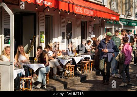 Francia, Parigi, Montmartre, Place du Tertre, clienti seduti al sole primaverile all'esterno del ristorante Chez Eugene Foto Stock