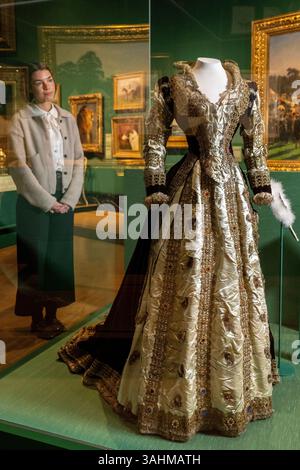 Londra, Regno Unito. 10 aprile 2025. Un membro dello staff con «Alexandra's costume as Mary, Queen of Scots», 1871, di Madame Elise, in anteprima di The Edwardians: Age of Elegance alla King’s Gallery, Buckingham Palace. La mostra esplora le vite e i gusti di due delle coppie reali britanniche, re Edoardo VII e regina Alessandra, e re Giorgio V e la regina Maria, e si svolge dall'11 aprile al 23 novembre 2025. [Utilizzo - notizie solo per scopi editoriali in relazione alla mostra] crediti: Stephen Chung / Alamy Live News Foto Stock