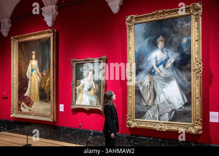 Londra, Regno Unito. 10 aprile 2025. Un membro dello staff con (R) «Queen Alexandra», 1908, di Francois Flameng e altre opere in anteprima di The Edwardians: Age of Elegance alla King’s Gallery, Buckingham Palace. La mostra esplora le vite e i gusti di due delle coppie reali britanniche, re Edoardo VII e regina Alessandra, e re Giorgio V e la regina Maria, e si svolge dall'11 aprile al 23 novembre 2025. [Utilizzo - notizie solo per scopi editoriali in relazione alla mostra] crediti: Stephen Chung / Alamy Live News Foto Stock