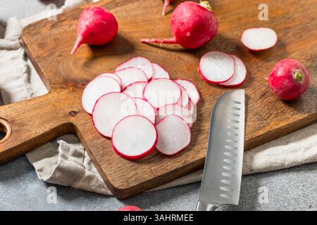 Fette di ravanello con taglio rosso organico su un tagliere Foto Stock
