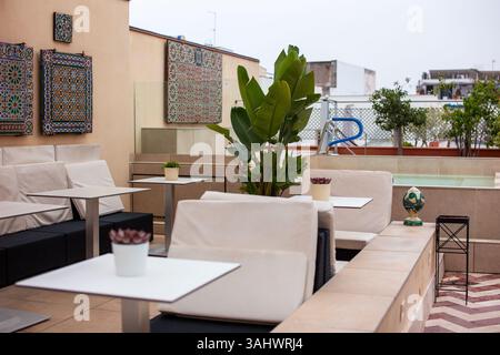Accogliente area lounge con vibrazioni marocchine e piastrelle a motivi geometrici Foto Stock