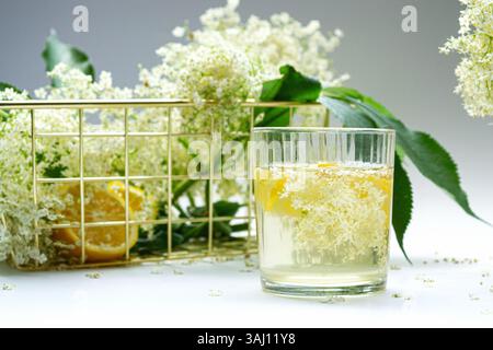 Un bicchiere di limonata di sambuco biologica fatta in casa con fiori e limone Foto Stock