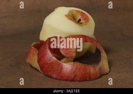 Immagine di una mela sbucciata con una buccia accanto ad essa Foto Stock