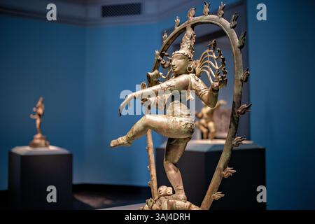 WASHINGTON DC - la scultura in bronzo "Shiva as Lord of Dance (Nataraja)" presso lo Smithsonian National Museum of Asian Art rappresenta una delle immagini più iconiche dell'induismo. Creato a Tamil Nadu, in India, durante la dinastia Chola intorno al 990 d.C., questo capolavoro raffigura il dio Shiva che danza all'interno di un anello di fuoco, simboleggiando i cicli cosmici della creazione e della distruzione. La figura di bronzo si bilancia su una gamba in cima a un nano che rappresenta l'ignoranza, con le mani che mostrano gesti simbolici, tra cui il mudra "non temere" e tenendo in mano un tamburo che batte l'universo fino all'esistenza. Foto Stock