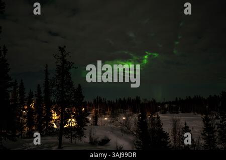 L'aurora boreale (Aurora Boreale) sopra i tepee illuminati nelle foreste vicino a Yellowknife, territori del Nord-Ovest, Canada Foto Stock