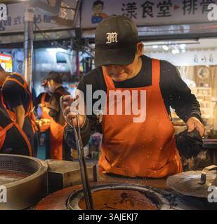 Bancarelle di cibo vendicativo di strada al mercato notturno di Raohe a Taipei, Taiwan Foto Stock