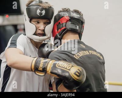 Due pugili sono sul ring, uno con una maglietta bianca Foto Stock