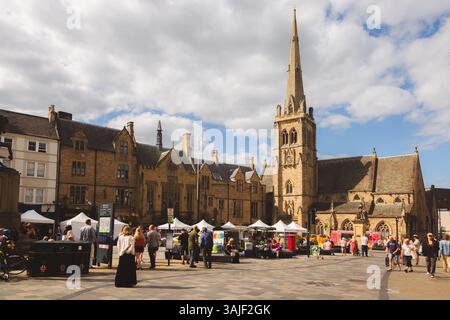 Durham, Regno Unito - 22 giugno 2024: Vivace città vecchia, mercato con vivaci bancarelle, architettura storica e Chiesa di San Nicola sul sole Foto Stock