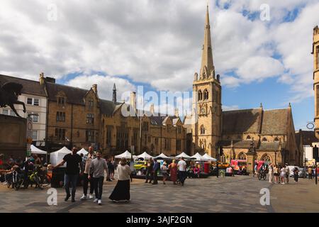 Durham, Regno Unito - 22 giugno 2024: Vivace città vecchia, mercato con vivaci bancarelle, architettura storica e Chiesa di San Nicola sul sole Foto Stock